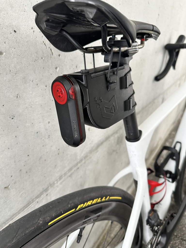 Pocket Small mounted under a road bike saddle, with a rear radar light attached